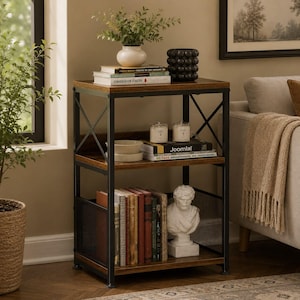May include: A three-tier shelving unit with a black metal frame and dark wood-toned shelves. The unit features X-shaped side supports, a mesh side panel on the bottom shelf, and adjustable feet. It holds books, a white vase, and a bust sculpture.
