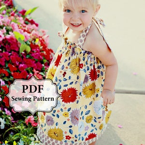 May include: A PDF sewing pattern for a yellow floral dress with a brown polka dot trim. The dress is sleeveless and has a gathered bodice. The pattern is available for download.