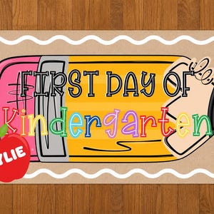 May include: A rectangular sign with a wavy white border on a tan background featuring a large yellow pencil illustration. The text reads FIRST DAY OF Kindergarten in black and colorful letters. A red apple with the name KYLIE is in the corner.