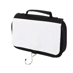 May include: Black and white hanging travel bag with a handle and a metal hook. The bag has a large white panel on the front, perfect for customization. The bag is designed for toiletries and travel.