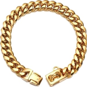 Puede incluir: Un brazalete de cadena dorada con eslabones gruesos y un cierre seguro. El brazalete está hecho de metal pulido con una superficie brillante y reflectante. Los eslabones son gruesos y están estrechamente conectados, formando un accesorio robusto.