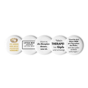 Peut inclure: Ensemble de cinq badges ronds blancs avec du texte noir et des accents dorés. Les badges présentent des phrases et des citations allemandes. Un badge comporte un motif de couronne dorée. Ces badges sont pour vêtements ou accessoires.