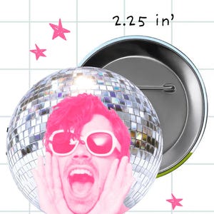 May include: A 2.25-inch button featuring a pink-toned image of a person wearing sunglasses and a disco ball. The person is screaming with their hands on their face. The button has a metal backing and a pin.