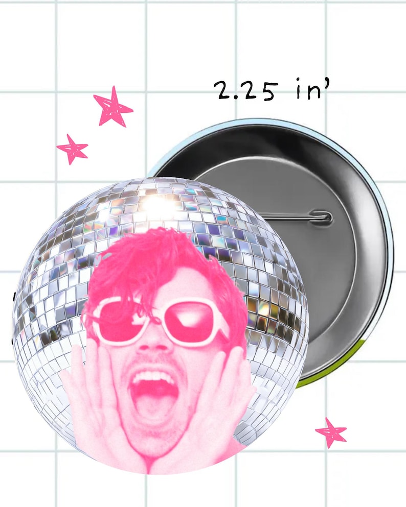 May include: A circular pin-back button featuring a disco ball graphic with a person wearing white sunglasses and shouting, with hands pressed against their cheeks. The text 2.25 in is visible, indicating the diameter of the button in inches.