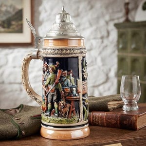 Pode incluir: Uma caneca de cerveja de cerâmica com tampa metálica e alça em forma de galho. O corpo apresenta um relevo de caçadores com um cão numa floresta, pintado em tons de azul, verde e castanho. O texto "Aufbouhz Jaga" é visível na base.