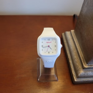 K&ouml;nnte beinhalten: Eine wei&szlig;e Keramik-Tasse mit schwarzem Henkel und dem Text "But First, Coffee" in schwarzer, fetter Schrift. Die Tasse steht auf einer wei&szlig;en Oberfl&auml;che.