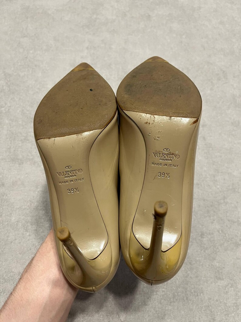 Puede incluir: Par de zapatos de tac&oacute;n Valentino beige, talla 39 1/2, con tacones de aguja. Las suelas est&aacute;n desgastadas y los tacones tienen un ligero tinte amarillo. Los zapatos est&aacute;n hechos en Italia.