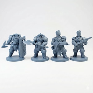 Puede incluir: Cuatro figuras en miniatura grises de figuras blindadas, cada una sobre una base circular. Las figuras están armadas con armas, incluyendo un hacha, un escudo y una ametralladora. Las figuras están en posición de combate.