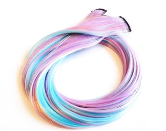 May include: A set of colourful hair extensions in shades of blue, pink and white. The extensions are arranged in a circle, showing the different colours.