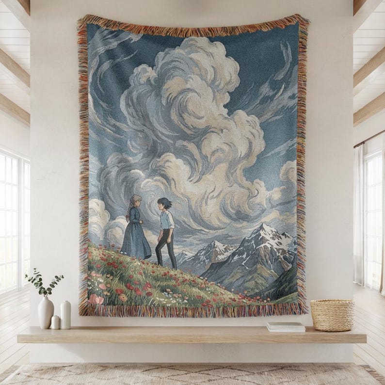 May include: A woven tapestry featuring a scenic landscape with two figures on a flowered hill, mountains, and a cloudy sky. The tapestry has a blue background and a fringed border.