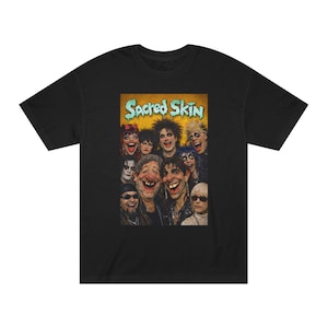 May include: Black t-shirt featuring a graphic of a group of people with exaggerated features and the text "Sacred Skin" in a teal and yellow font. The image has a vintage, slightly distressed look.