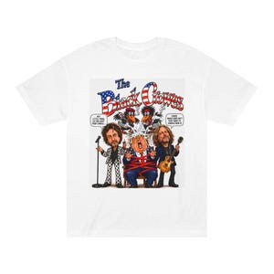 May include: A white t-shirt featuring a graphic illustration of The Black Crowes with two cartoon crows above a central figure tied in red tape. The text reads The Black Crowes, Hey little thing let me light your candle, and Cause MAGA sure ain't that hard to handle now.