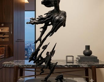 May include: A matte black sculpture depicting a human figure in motion, with the upper body transitioning into abstract, flowing forms that extend downward toward a solid oval base. The figure features wind-swept hair and draped clothing.
