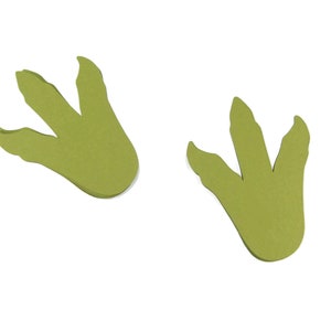 Puede incluir: Dos huellas de dinosaurio verdes recortadas en papel.