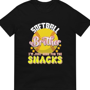 Op de afbeelding: Zwart T-shirt met een softbalafbeelding. Het ontwerp toont een gele softbal met de tekst "SOFTBALL Brother" en "I'M JUST HERE FOR THE SNACKS" in wit en geel.