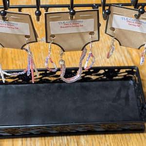 May include: Three sets of red, white, and blue beaded jewelry on brown cardboard display cards labeled TLK Creations Stars & Stripes. The jewelry includes bracelets and earrings with small seed beads hanging from silver-toned metal hooks.
