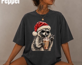 Camiseta navideña Comfort Colors® con estampado de mapache, divertida camiseta de mapache con gorro de Papá Noel, camiseta navideña para amantes del café, regalo navideño con gafas de sol de mapache