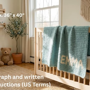 May include: A light blue crochet blanket, approximately 91 x 102 cm, draped over a wooden cot. The name "EMMA" is stitched in white. The room includes a teddy bear, a small tree, and a macrame wall hanging.