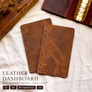 May include: Two rectangular brown leather dashboard inserts for ring planners, each featuring six punched holes along the left edge. The text LEATHER DASHBOARD RING PLANNER INSERT / PAGE LIFTER is printed below, with size labels A5, B6, B6 PERSONAL, and A6.