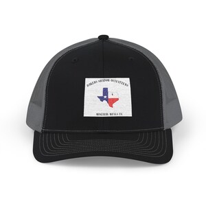 Könnte beinhalten: Schwarze und graue Trucker-Cap mit einem quadratischen Aufnäher mit der Texas-Staatsflagge und dem Text "Bikers Shadow Outfitters Mineral Wells TX". Die Kappe hat einen gebogenen Schirm und eine Mesh-Rückseite.