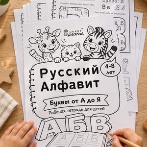 Pode incluir: Um caderno de exercícios em papel branco intitulado "Русский Алфавит" para crianças de 4 a 8 anos, com desenhos de linhas em preto e branco de uma girafa, um gato e uma zebra. A capa inclui o texto "SMART peanut," "Буквы от А до Я" e "Рабочая тетрадь для детей" com as letras grandes A, Б e B na parte inferior.