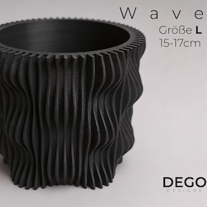 Könnte beinhalten: Schwarzer Pflanztopf mit Wellenmuster und strukturierter Oberfläche. Der Topf ist mit "Wave" und "Größe L 15-17cm" beschriftet. Der Topf ist ein Produkt von DEGO DESIGNS. Der Topf ist etwa 15 bis 17 cm hoch.