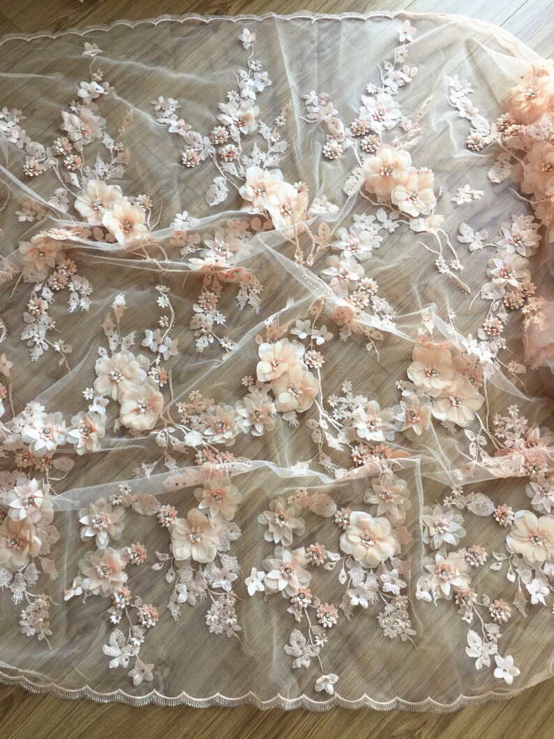 Puede incluir: Tela de encaje floral de color melocot&oacute;n con flores 3D y cuentas. La tela es transparente y delicada, con un borde festoneado.