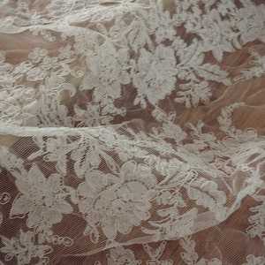 May include: White lace fabric with a floral pattern. The lace is delicate and intricate, with a soft, flowing texture.