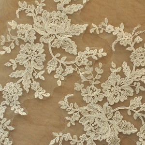 May include: White lace trim with a floral design. The lace features delicate flowers and leaves.