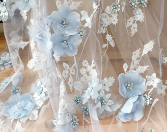 Puede incluir: Tela de encaje floral azul claro con flores 3D. La tela tiene una textura delicada y transparente, ideal para añadir un toque de elegancia a cualquier proyecto.