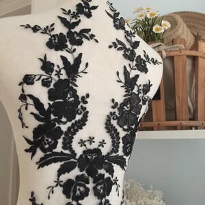 May include: Black floral lace applique with a delicate design. The lace is perfect for adding a touch of elegance to any garment.
