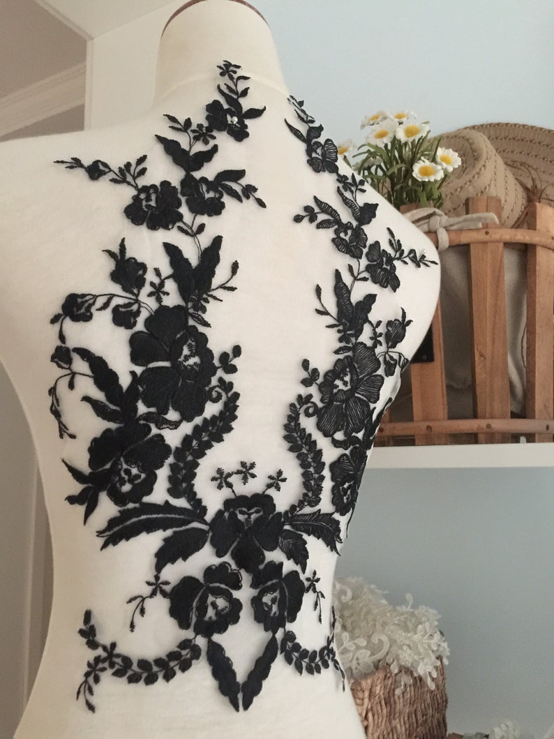 May include: Black floral lace applique with a delicate design. The lace is perfect for adding a touch of elegance to any garment.