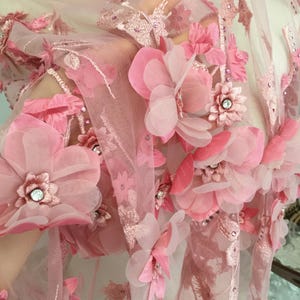 Puede incluir: Tela de encaje floral rosa con flores 3D. La tela es transparente y delicada, con una sensaci&oacute;n suave y femenina.