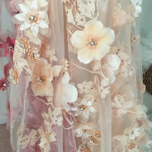 Puede incluir: Tela de encaje floral de color melocot&oacute;n y blanco con flores 3D y pedrer&iacute;a. La tela es transparente y delicada.