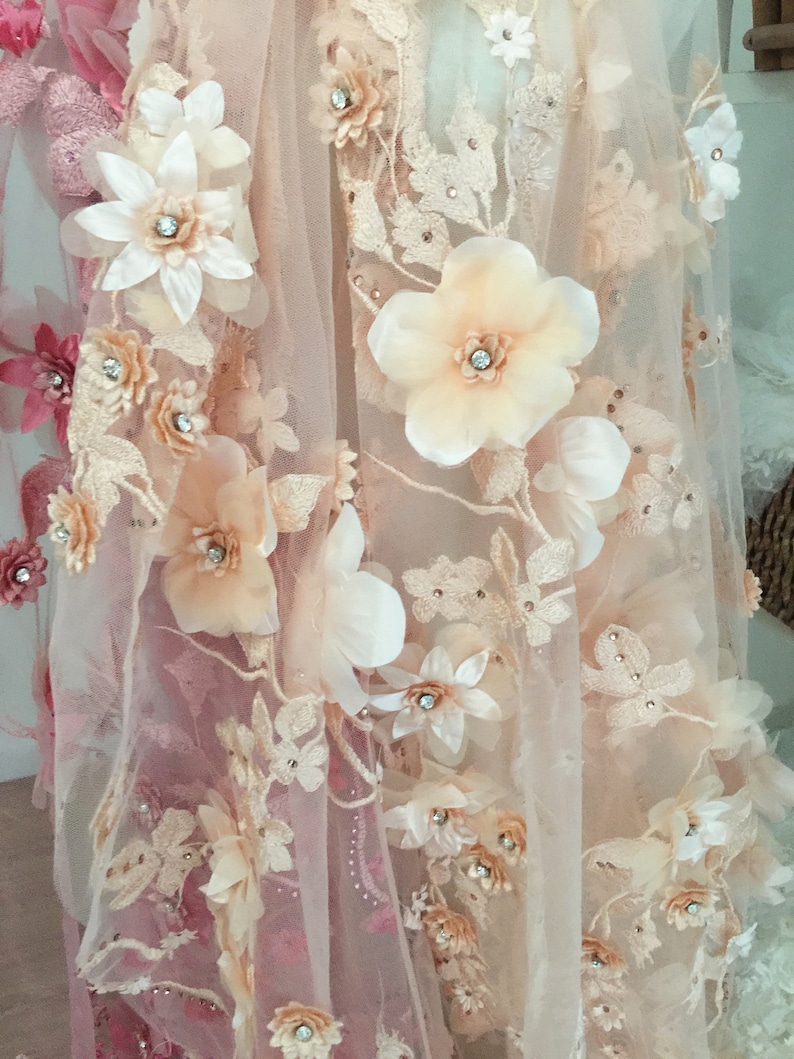 Puede incluir: Tela de encaje floral de color melocot&oacute;n y blanco con flores 3D y pedrer&iacute;a. La tela es transparente y delicada.