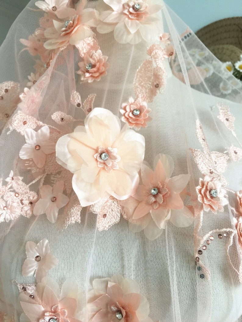 Puede incluir: Tela de encaje floral de color melocot&oacute;n con flores 3D y pedrer&iacute;a. La tela es transparente y delicada, perfecta para a&ntilde;adir un toque de elegancia a cualquier proyecto.