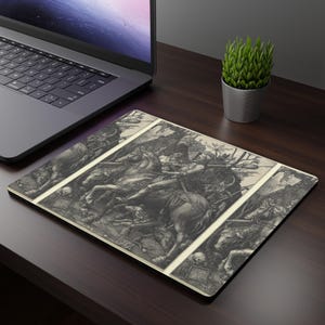 Peut inclure: Un tapis de souris rectangulaire avec une illustration détaillée en noir et blanc d'une scène de bataille avec des personnages montés et des armes. L'œuvre est encadrée par une bordure claire. Un ordinateur portable et une plante en pot sont en arrière-plan.