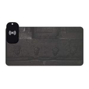 Peut inclure: Un tapis de chargement sans fil noir avec un motif sombre en forme de pierre. Le tapis présente quatre visages sculptés et un palet de chargement noir avec un symbole sans fil. Le design a un thème vintage et classique.