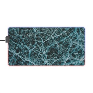 Peut inclure: Tapis de souris rectangulaire avec un motif de glace craquelée bleu foncé et blanc. Le tapis a un bord lumineux à LED avec des lumières rouges et bleues. Un connecteur USB noir est attaché.