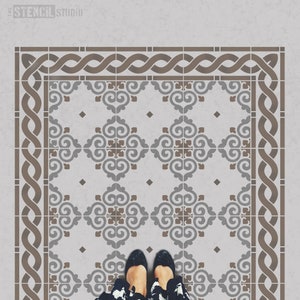 May include: A stencil for creating a decorative floor design. The stencil features a repeating pattern of stylized swirls and a border of interlacing ropes. The stencil is shown on a light gray surface.