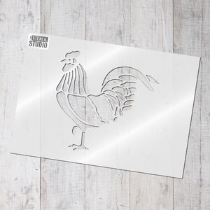 Op de afbeelding: Een sjabloon van een haan, een veelvoorkomend boerderijdier, in een eenvoudige lijntekeningstijl. De sjabloon is gemaakt van wit plastic en klaar om te gebruiken voor knutselprojecten.
