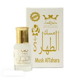 Puede incluir: Un pequeño frasco de perfume con tapón dorado y etiqueta blanca, junto a una caja blanca. La caja y el frasco tienen texto árabe y las palabras "Musk AlTahara". El frasco está lleno de un líquido transparente.