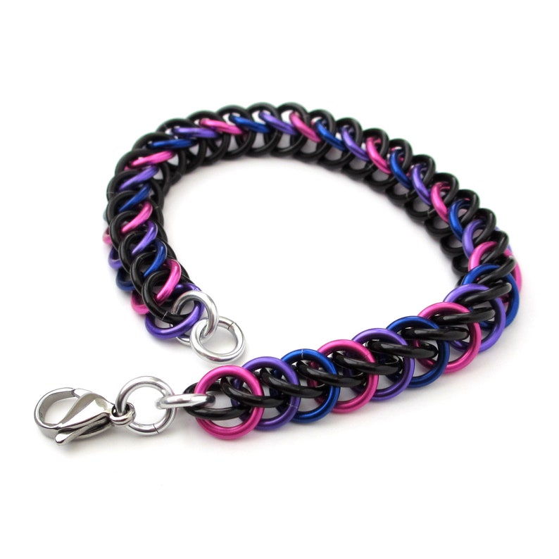 May include: A black, pink, and blue chainmail bracelet with a silver lobster clasp.