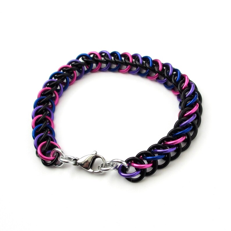 May include: A black, blue, and pink chainmail bracelet with a silver clasp.