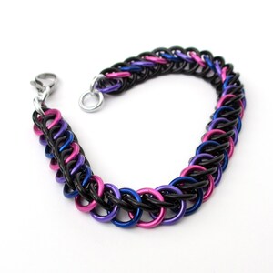 May include: A black, blue, and pink chainmail bracelet with a silver clasp.