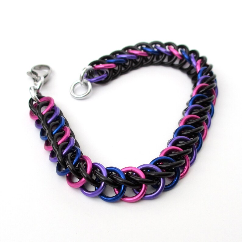 May include: A black, blue, and pink chainmail bracelet with a silver clasp.