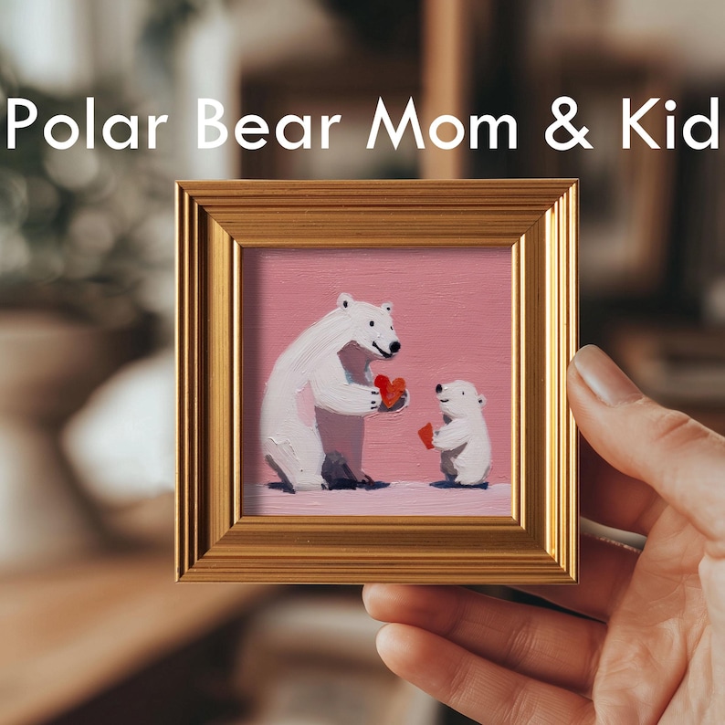 K&ouml;nnte beinhalten: Gerahmtes Gem&auml;lde mit dem Text "Polar Bear Mom & Kid". Das Kunstwerk zeigt einen Eisb&auml;ren und ein Junges, die rote Herzen vor einem rosa Hintergrund halten. Der Rahmen ist goldfarben.