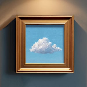 May include: A framed painting of a fluffy white cloud against a light blue sky. The artwork is encased in a gold-colored, rectangular frame. The painting evokes a sense of calm and serenity.