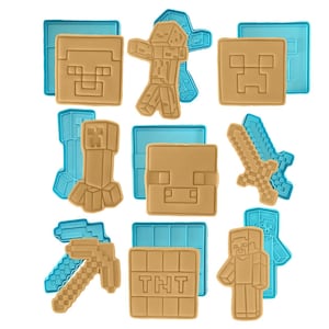 May include: A collection of tan and blue Minecraft-themed cookie cutters. The set includes various character and item shapes, such as a Creeper, a sword, and a pickaxe. The cutters are made of plastic and are designed for baking.