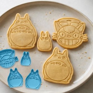 Peut inclure: Des emporte-pi&egrave;ces et des biscuits sur le th&egrave;me de Totoro. Les biscuits sont brun clair et en forme de Totoro et de Catbus. Des d&eacute;coupoirs en plastique bleu sont &eacute;galement pr&eacute;sents.